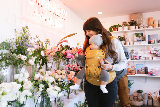 image of woman wearing yellow baby carrier