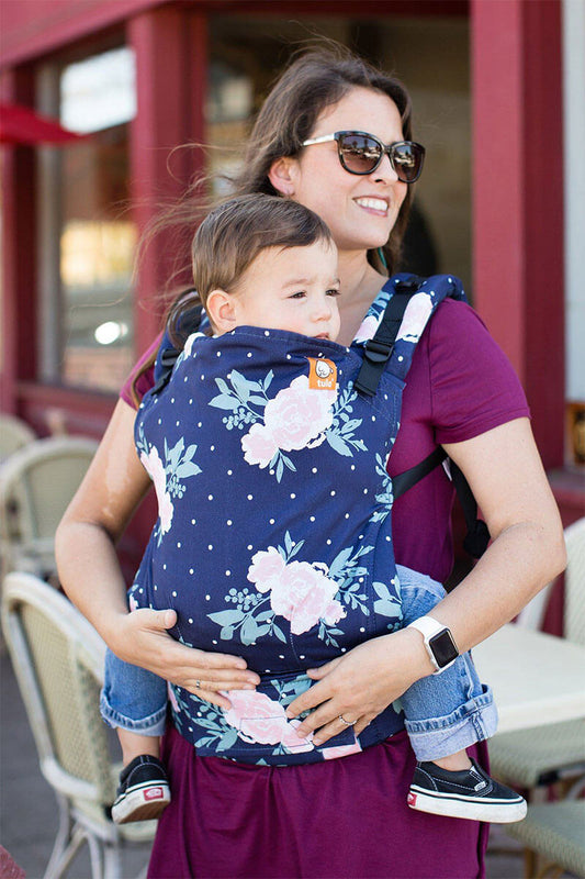 image of woman wearing a baby in floral carrier