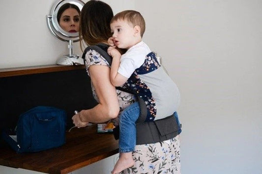 image of woman holding baby in baby carrier