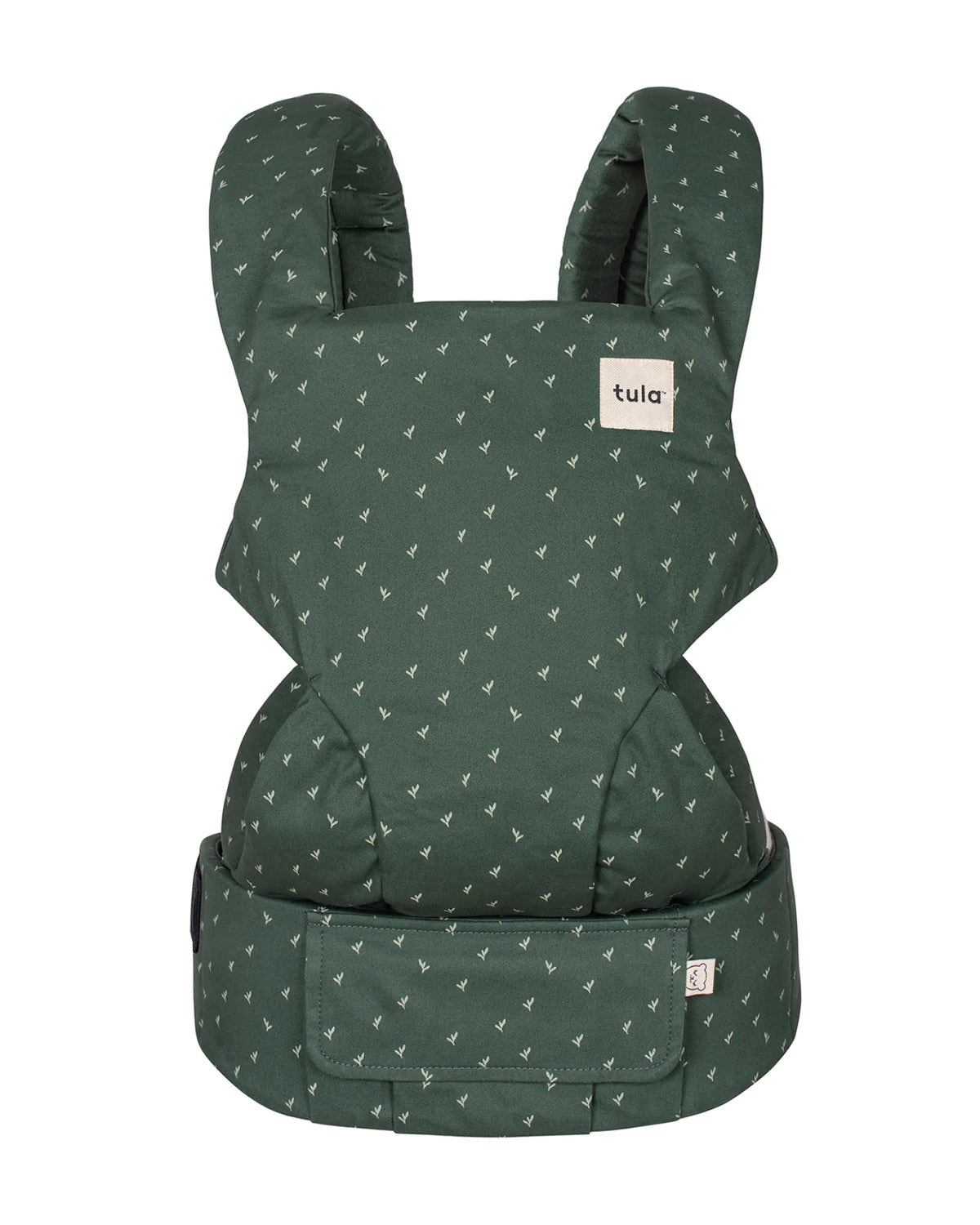 A dark green baby carrier with a small white geometric pattern, featuring a white brand label that reads 'tula' on the front.