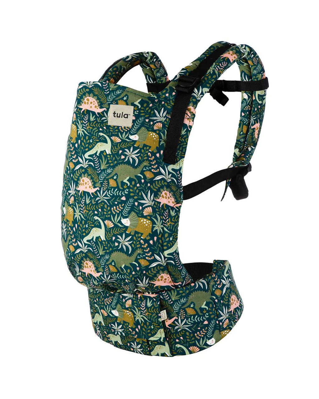 A mesh baby carrier with a dark green tropical jungle print featuring dinosaurs, lizards, and leaves, with black adjustable shoulder straps and a white brand label reading 'tula'.