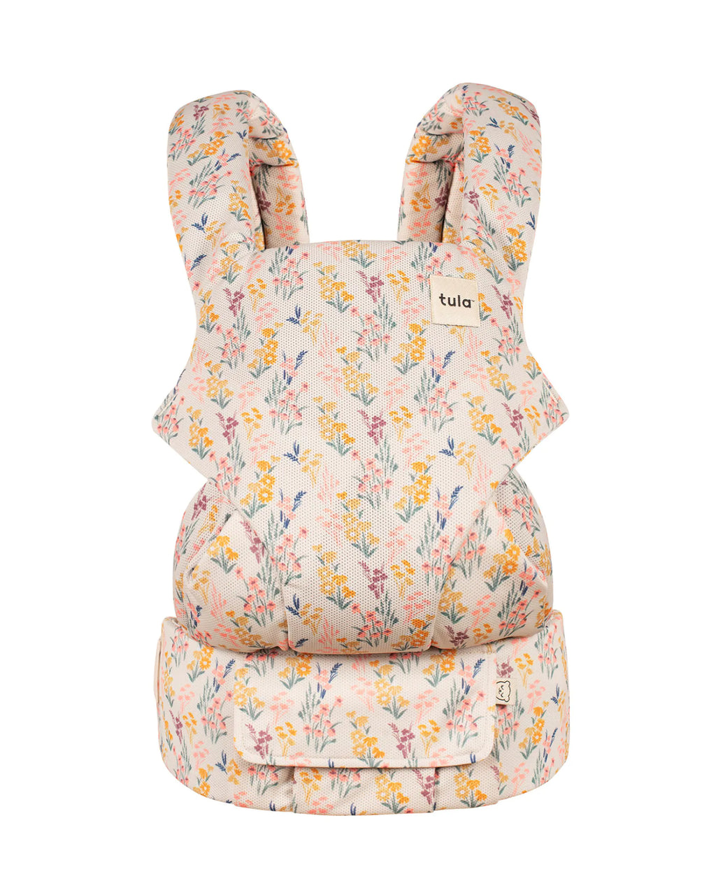 A Tula baby carrier with a light pink and cream floral pattern, shown against a plain white background.