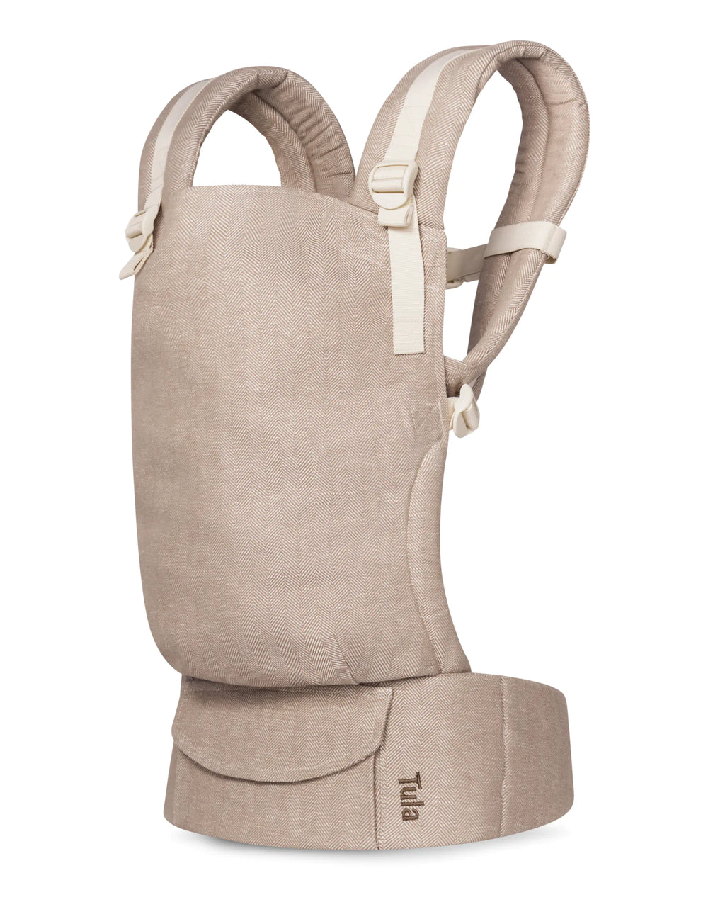 A Tula linen baby carrier in a light beige linen-like fabric, shown from the side against a plain white background.