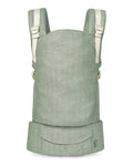 A sage green linen baby carrier with cream-colored shoulder straps and a front utility pocket, shown against a plain white background.