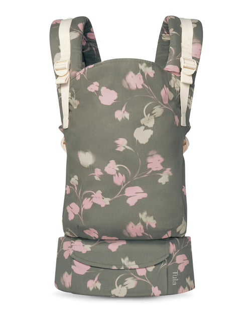 A cotton baby carrier in a muted sage green fabric with a pink and cream floral vine pattern, shown against a plain white background.