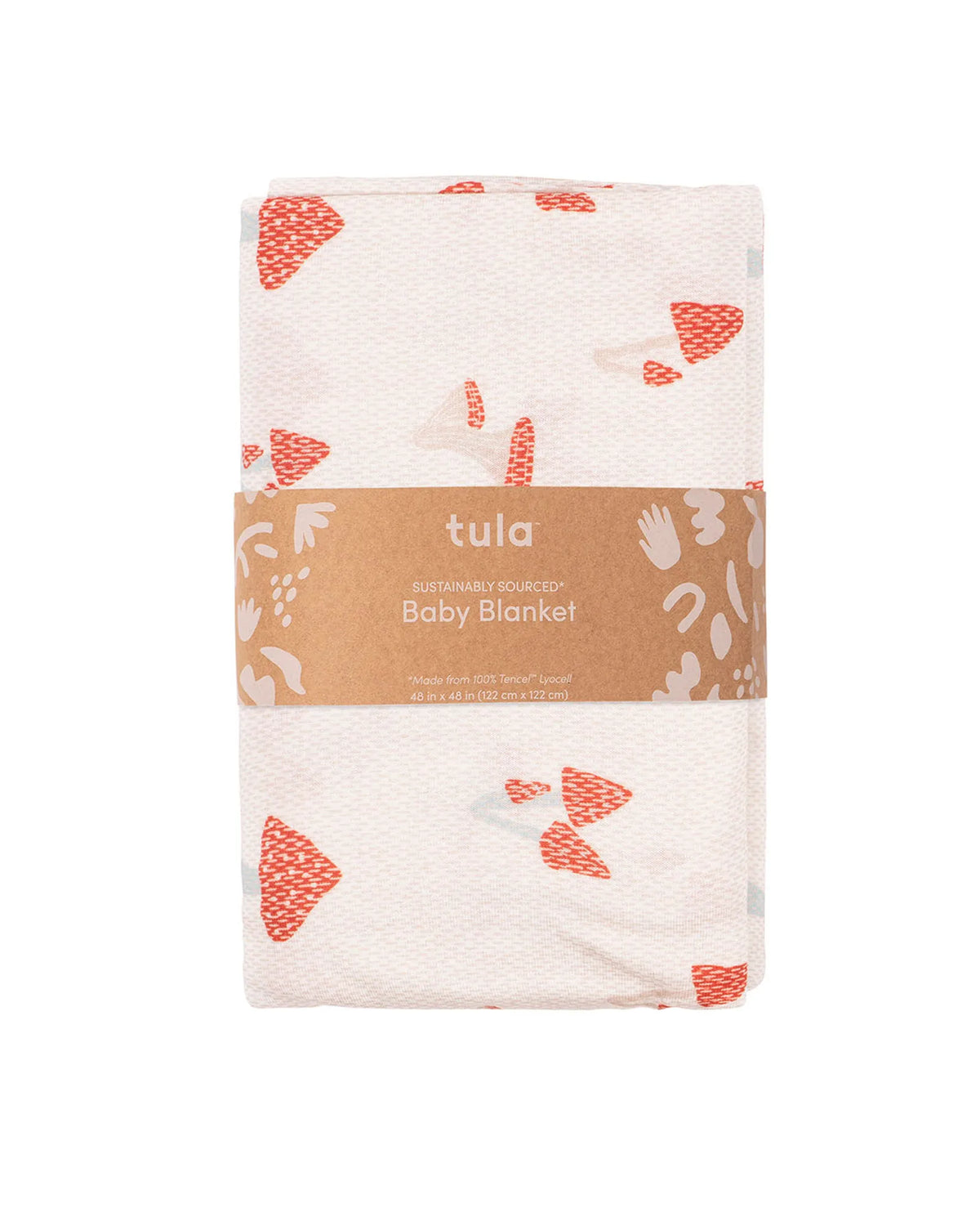 A folded baby blanket by Tula, made from sustainable cotton, featuring a white base with coral orange abstract shapes and a brown paper band wrapped around the middle.